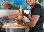 São Vicente - Frau bereitet in Küche Fische zum Kochen vor